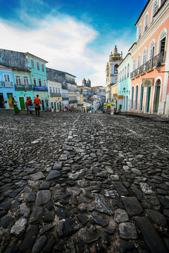 Cores urbanas do Pelourinho, em Salvador, na Bahia. Detalhes das constru&ccedil;&otilde;es e das pedras da rua. Pessoas distantes.