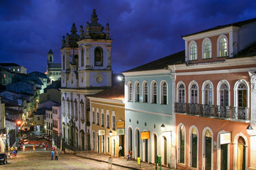Cores urbanas do Pelourinho, em Salvador, na Bahia. Detalhes das construções e das pedras da rua. Pessoas distantes.
