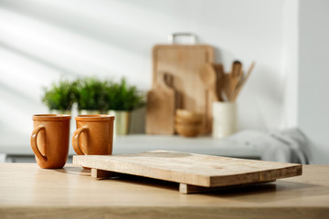 Fototapeta na wymiar Wooden table in a sunny kitchen in the morning light during breakfast