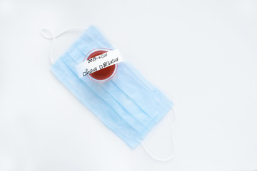 Flask with blood with test results on a medical mask.
