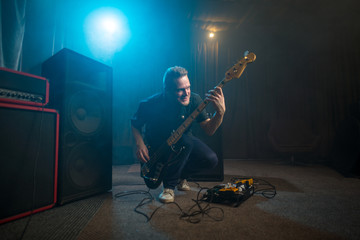 Obraz premium Musician playing an electric bass guitar on stage