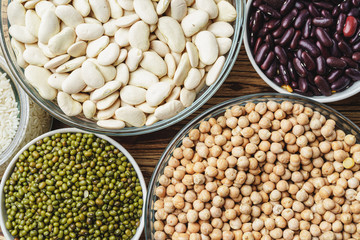 Assortment of beans on wooden background.