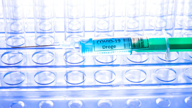 The drug Covid-19 Droge written in German syringe on top of the tubes for coronavirus