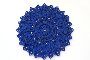 Handmade knitted blue openwork napkin. Beautiful work. Isolated on white background