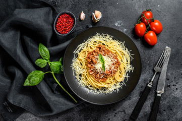 Spaghetti bolognese pasta with tomato and minced meat, parmesan cheese and basil. Black background....