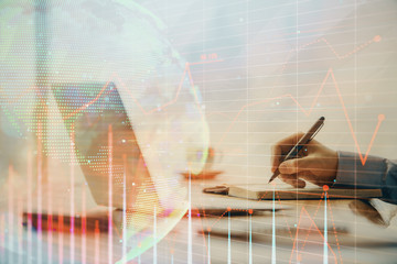 Double exposure of forex chart with man working on computer on background. Concept of market...