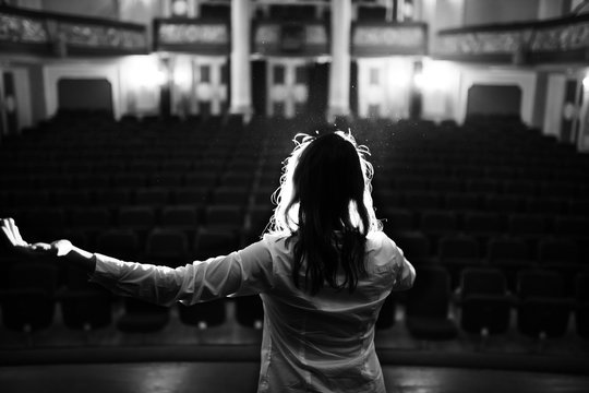 Entertainer Performing On A Stage In A Empty Theater,concert Hall Without Fans.No Audience.COVID-19 Canceled Show.Opera House Without Spectators.Playing To Empty Seats.Actor/singer Entertaining No One