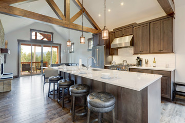 Amazing modern and rustic luxury kitchen with vaulted ceiling and wooden beams, long island with white quarts countertop. - obrazy, fototapety, plakaty