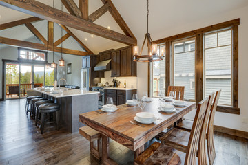 Amazing dining room near modern and rustic luxury kitchen with vaulted ceiling and wooden beams,...