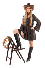 Fototapeta premium Girl with long blond hair with a cowboy hat in her hands, full length portrait. Isolate on a white background.