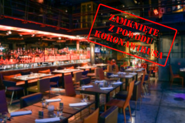 Defocused, blurred view of interior of an upmarket bar or restaurant, empty and closed due to covid 19 with Polish notice Closed due to Coronavirus