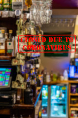 Defocused, blurred view of interior of traditional bar or pub, empty and closed due to coronavirus or covid 19 pandemics