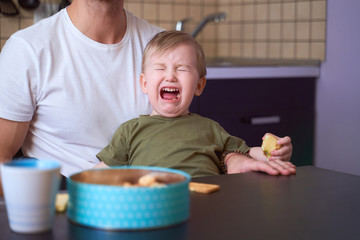 Small child bitterly bursts in tears, capricious, has bad mood, takes out brain of parents,...