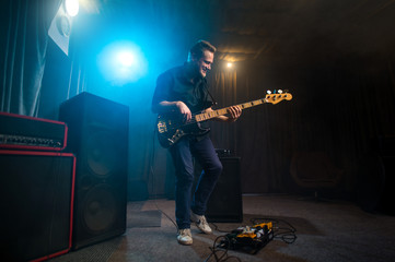 Musician playing an electric Bas-guitar on stage