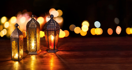 Ramadan lanterns on the table. Dark background with street light and bokehs. Beautiful Greeting...