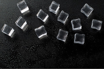 Fresh ice cubes and reflections on black background