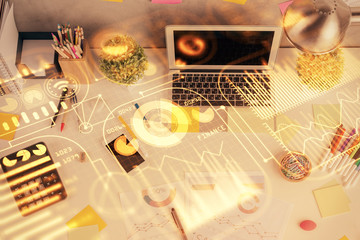 Technology hologram drawing over computer on the desktop background. Top view. Double exposure. Tech concept.