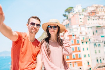 Young tourist couple traveling on european holidays outdoors in italian vacation in Cinque Terre