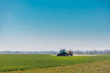 Fototapeta premium Tractor Spraying Herbicides on Field Agriculture