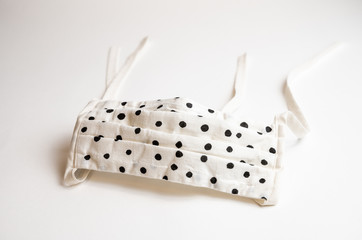 Home made face mask in black and white pattern for the COVID-19 pandemic on a white background
