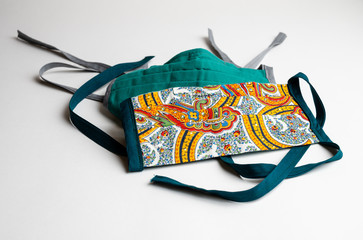 Naklejka premium Home made face masks in colorful patterns for the COVID-19 pandemic on a white background