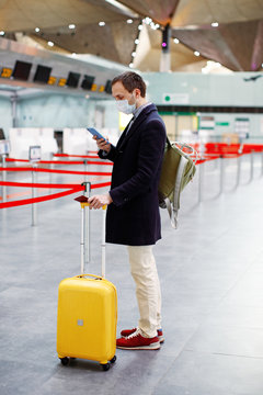 Man In Mask At Empty Airport At Check In In Coronavirus Quarantine Isolation, Waiting For Departure, Tourism Industry Crisis, Pandemic Infection Worldwide Spread, Travel Restrictions, Border Shutdown