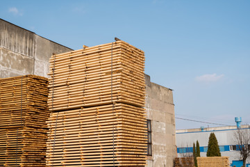 Warehouse for sawing boards on a sawmill outdoors. Timber mill, sawmill. Storage of planed wooden boards. Piles of wooden boards in the sawmill. Planking. Industry.