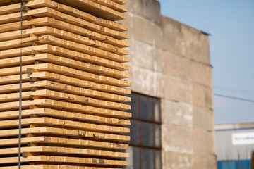 Warehouse for sawing boards on a sawmill outdoors. Timber mill, sawmill. Storage of planed wooden boards. Piles of wooden boards in the sawmill. Planking. Industry.