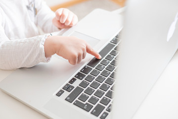 little kid's hands typing on laptop computer close up. distance education concept