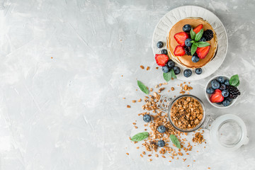 Fototapeta na wymiar Healthy breakfast with american pancake, granola, fruits, berries on white background.
