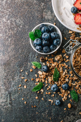Healthy breakfast with granola, yogurt, fruits, berries on dark metal background. Summer homemade breakfast.
