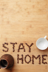 Stay Home lined with coffee beans, a copper cezva and a white porcelain cup
