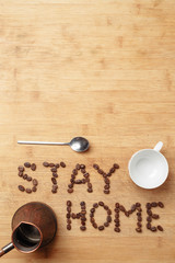 Roasted coffee beans, a spoon, a copper cezva and a white porcelain cup