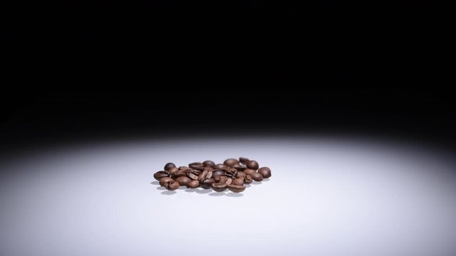 Coffee beans on white table under direct white light.