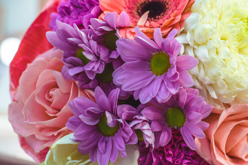 Colourful spiral bouquet of large pink rose, white amaryllis, coral gerbera,ears of wheat,purple carnation and chrysanthemum in the craft paper