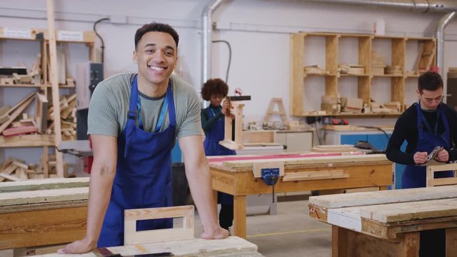 Portrait of male student in carpentry workshop studying for apprenticeship at college - shot in slow motion