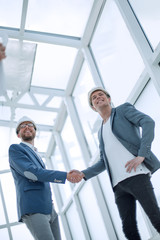 architects and engineers shaking hands in a new building.
