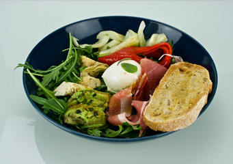 Fresh salad with chicken, tomatoes and mixed greens (arugula, mesclun, mache) on wooden background top view. Healthy food. Meat and vegetables.