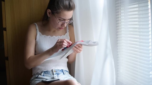 the girl is annoyed that she can t learn how to cross-stitch using the Internet. The girl continues to study hard and try again
