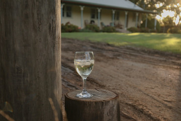 Glass of white wine on country property at sunset