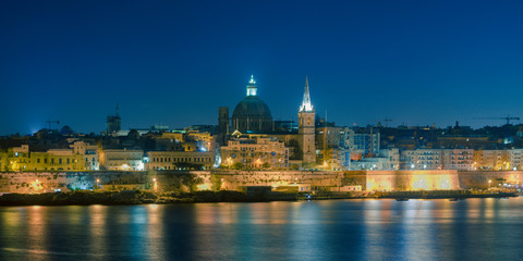 Obraz premium Malta's capital city Valletta, at night, from across the port in Sliema, with churches and buildings illuminated