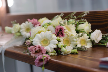 The wedding bouquet of roses, gerbera, lisianthus lies on the table