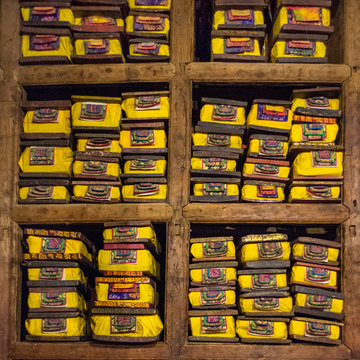 Ancient Sutras, or scriptures, wrapped in colorful silk and stacked, reside in Pelkor Chode Monastery