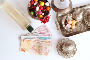 Turkish thousand lira on white with cologne,colorful candies and Turkish coffee set.Retirement Holiday Bonus concept in Turkey.