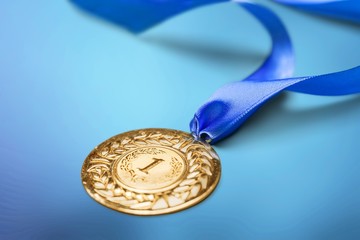 Gold medal with colored ribbon on desk