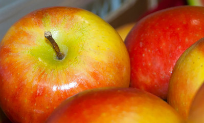 Red sweet apples close-up stacked in a box for sale.