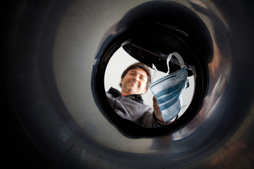 View from inside the trash of a happy man throwing away a mask