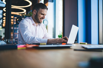 Cheerful skilled male IT professional satisfied with distance job on program code succeed with...