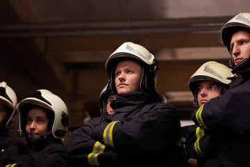 Group of six professional firefighters standing together. Firefighters wearing uniforms and protective helmets.