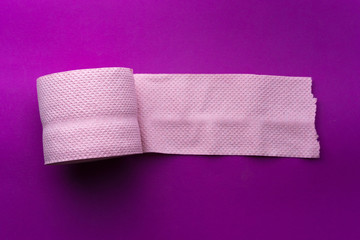roll of pink toilet paper on a purple background